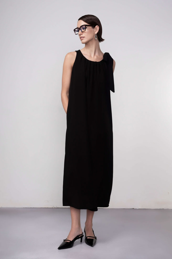 Robe longue élégante sans manches, coupe droite et fluide, avec encolure froncée noire pour une allure moderne et minimaliste.