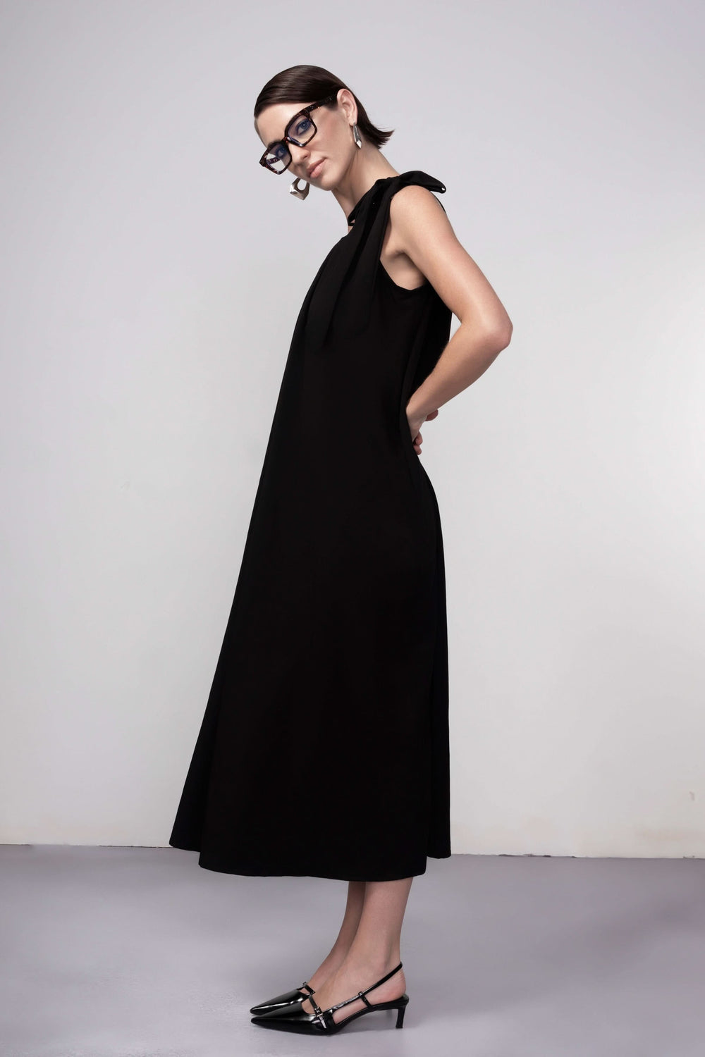 Robe longue élégante sans manches, coupe droite et fluide, encolure délicatement froncée, pour une allure moderne et minimaliste.