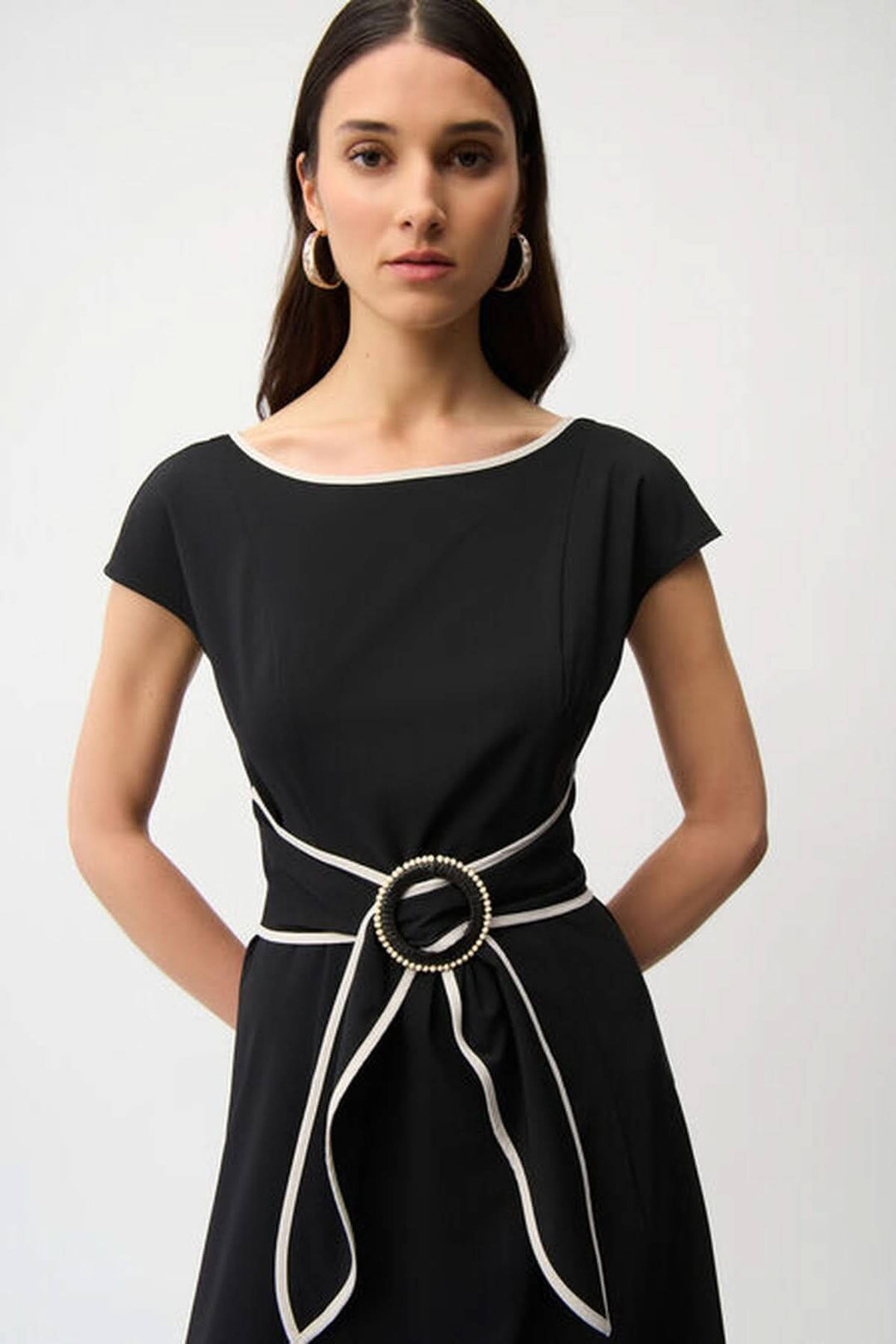 Robe midi ceinturée noire chic avec encolure bateau et ceinture à boucle anneau, idéale pour bureau ou événements élégants.