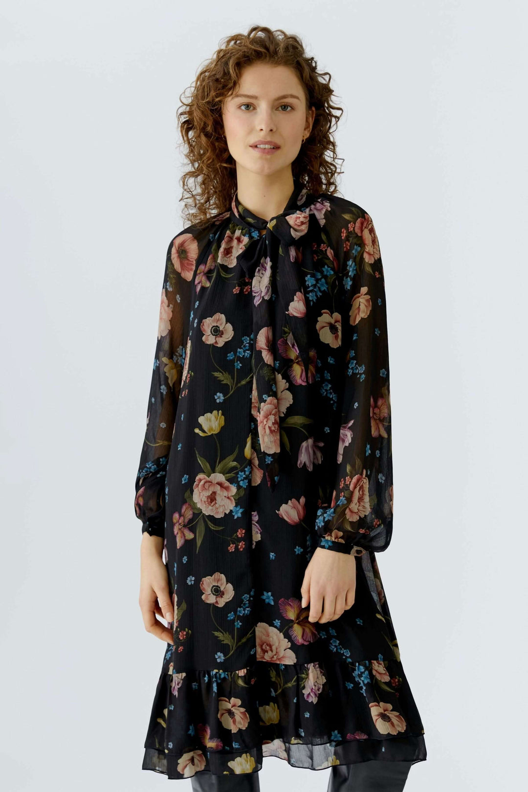 Robe midi fluide avec imprimé floral, coupe droite évasée et encolure délicate, portée par un mannequin.