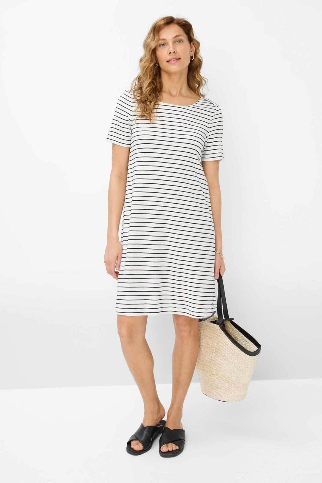 Femme portant une robe rayée GRACE, élégante et moderne, parfaite pour le printemps et l'été.