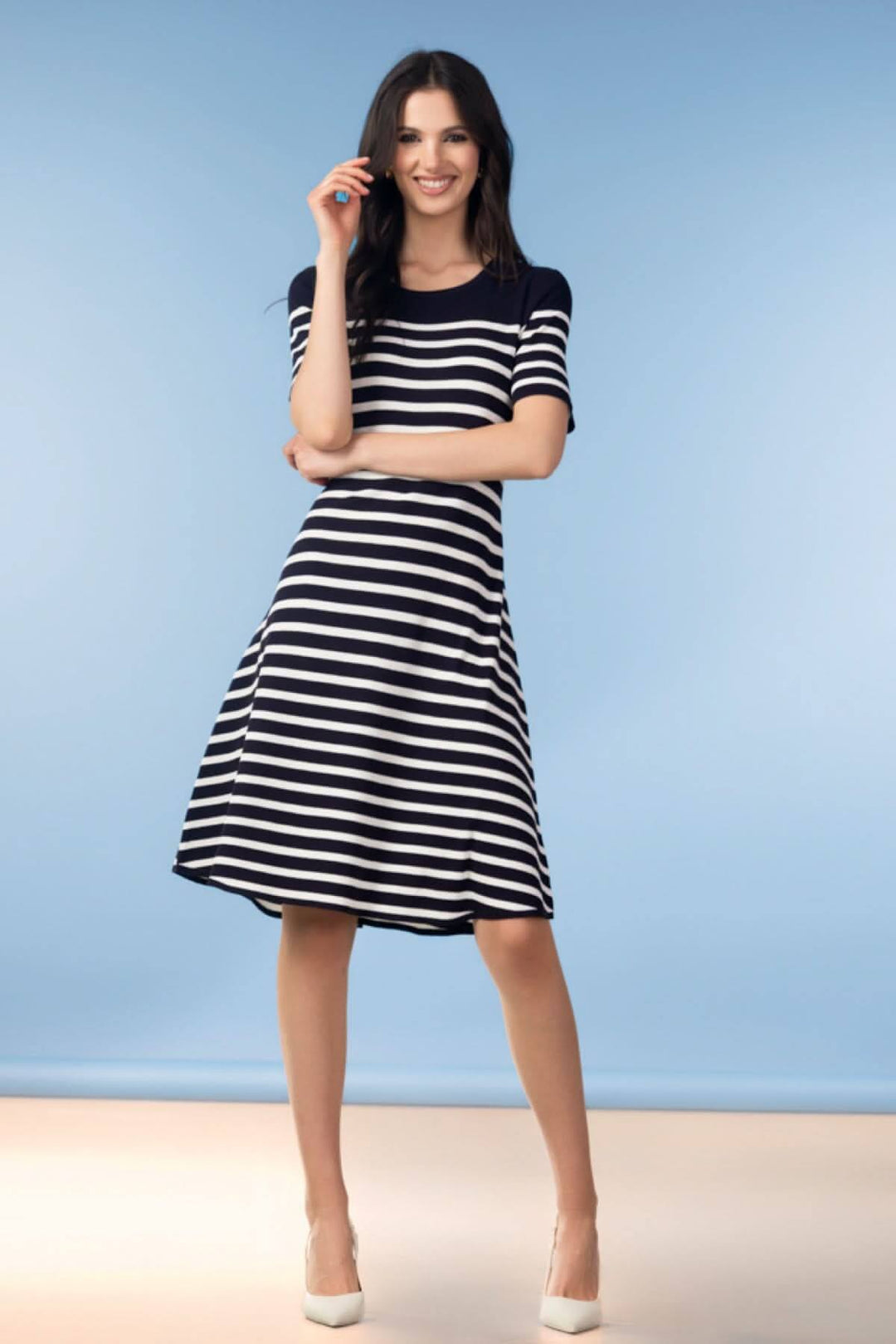 Femme portant une robe rayée manches courtes avec coupe évasée, idéale pour un look élégant et sans effort. Robe rayée manches courtes.