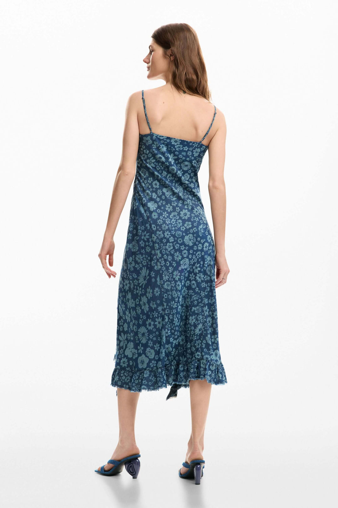 Femme portant une robe à volants en denim bleu à fines bretelles avec coupe ajustée et longueur midi, vue de dos.