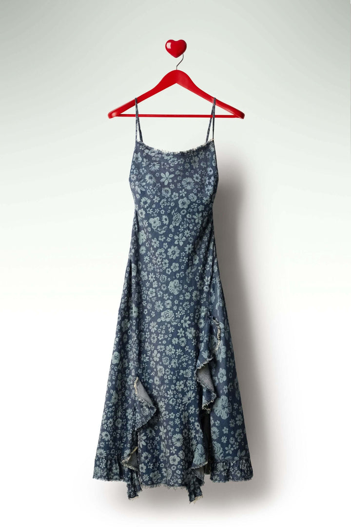Robe à volants en denim avec bretelles fines et volants asymétriques, silhouette ajustée élégante sur cintre rouge.