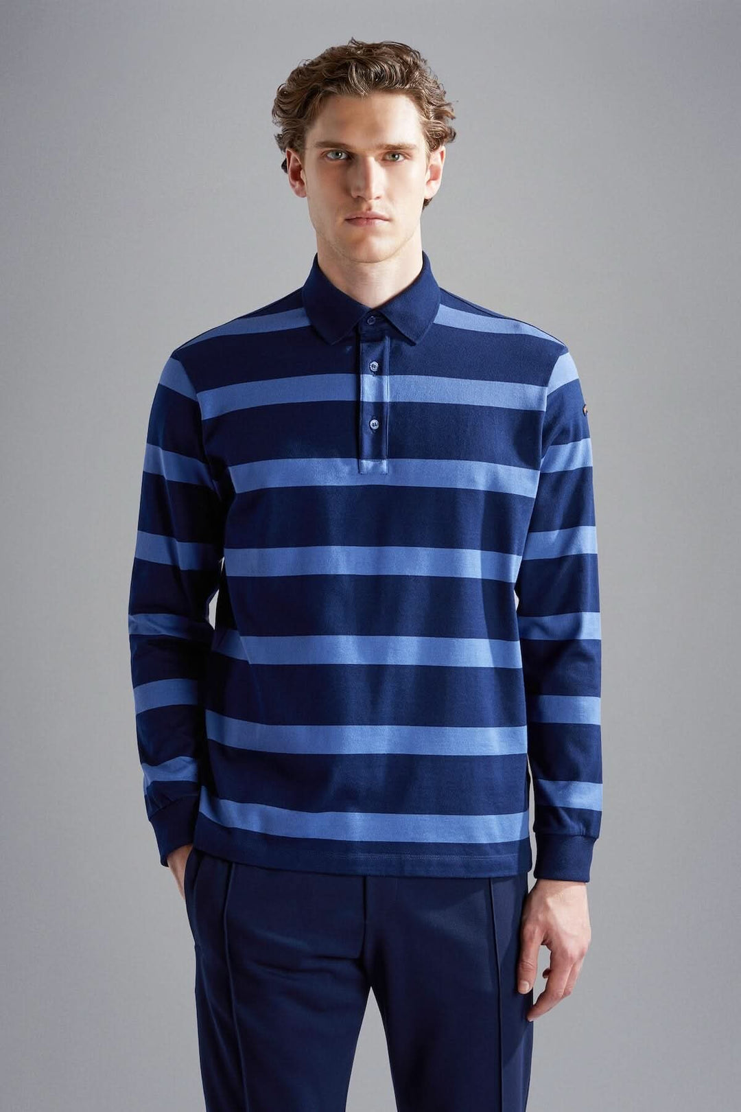 Polo rayé bleu marine et bleu clair pour homme, alliant élégance et confort moderne, idéal pour occasions décontractées.