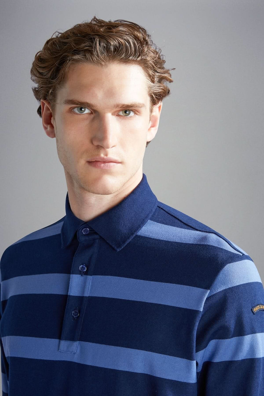Homme portant un polo rayé bleu marine et bleu clair, alliant élégance et confort.