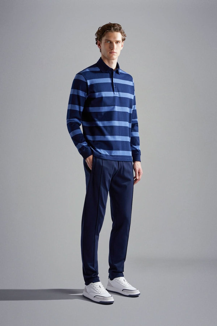 Polo rayé bleu marine et bleu clair, porté par un homme, idéal pour des occasions décontractées ou professionnelles.