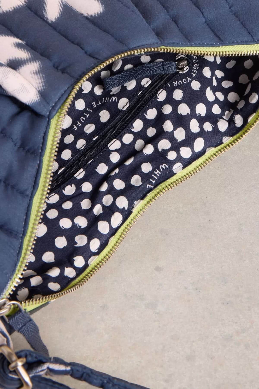 Intérieur du sac bandoulière Zoe avec motif pois sur fond bleu et fermeture à glissière.