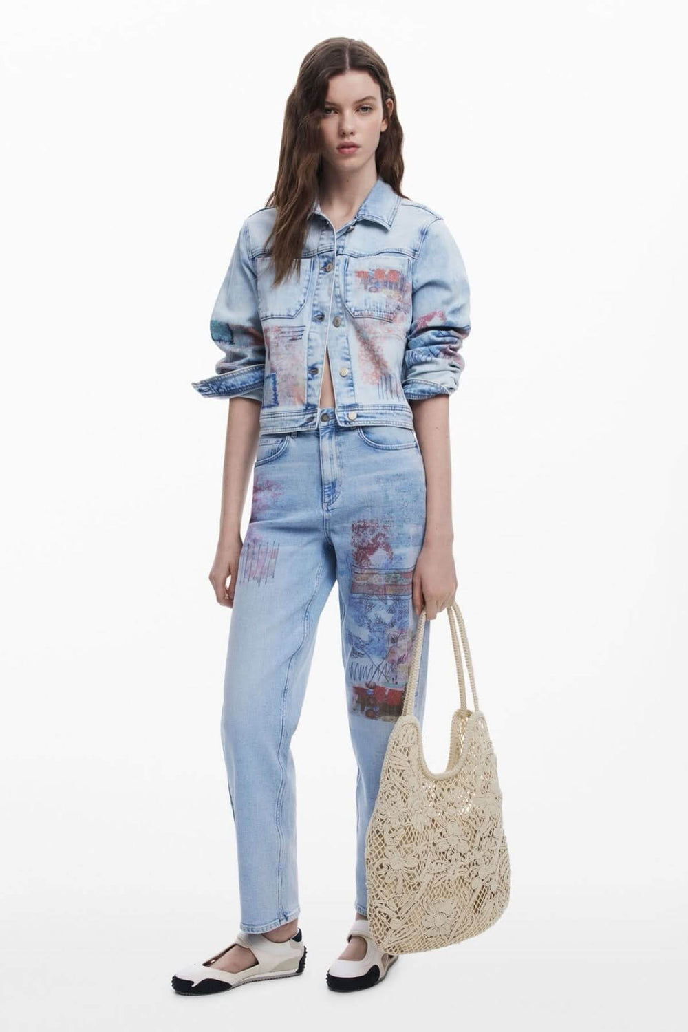 Femme en jean avec sac en crochet ajouré et chaussures noires, affichant un style décontracté et bohème.