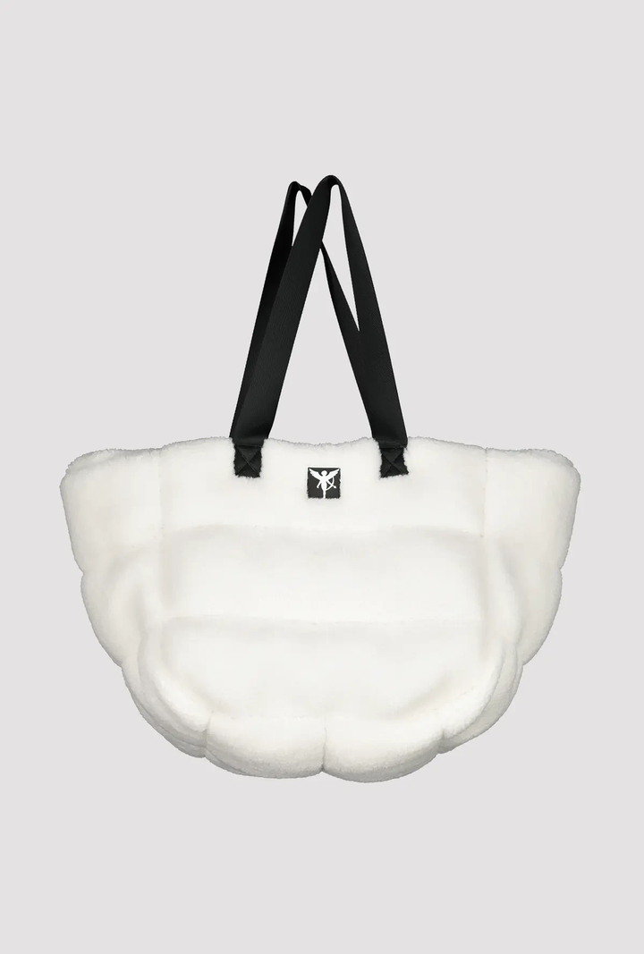 Sac en fourrure teddy blanc avec anses noires, parfait pour un style décontracté et moderne.