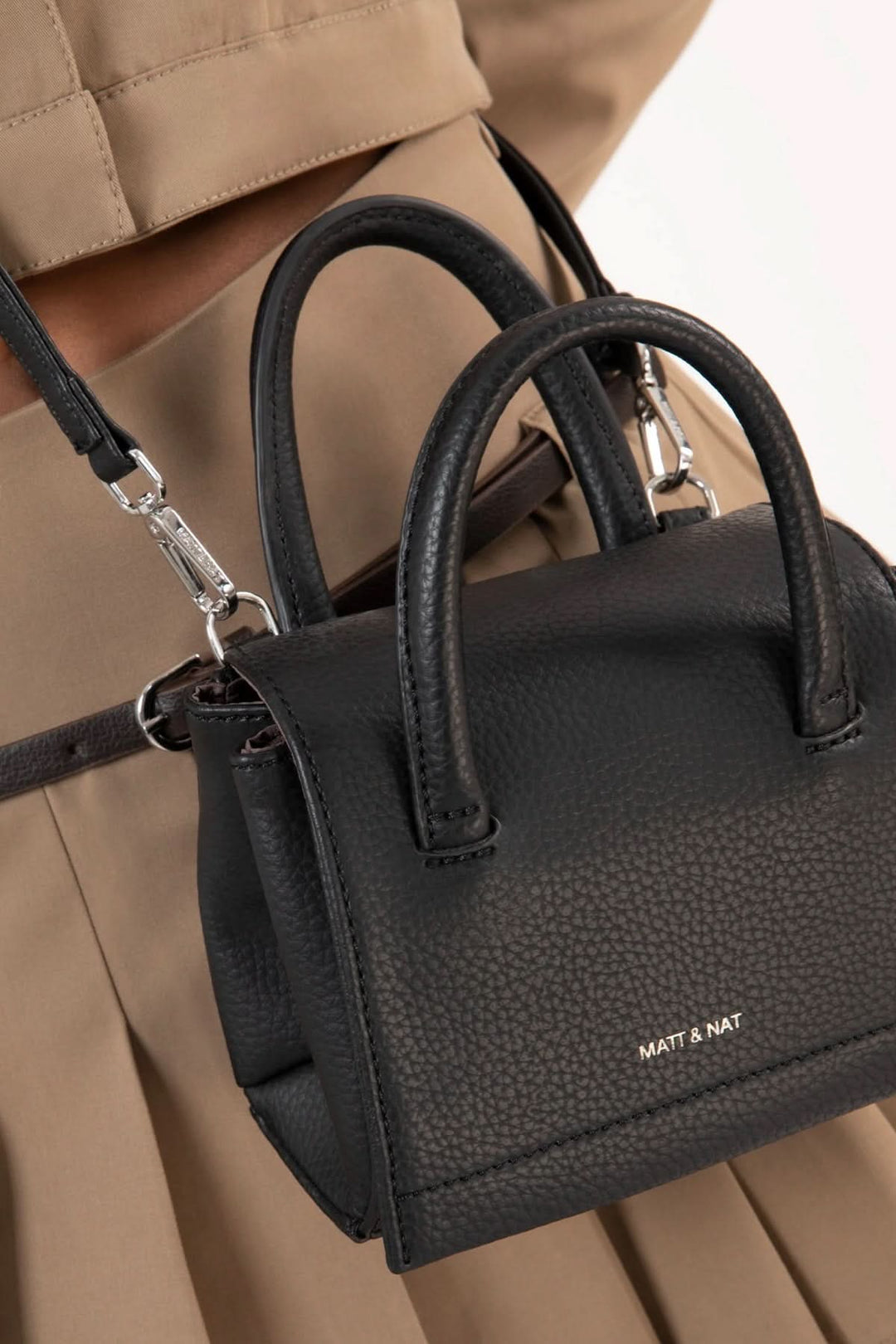 Sacoche Adelmicro vegan noire avec double poignées et bandoulière ajustable, idéale pour une tenue chic.