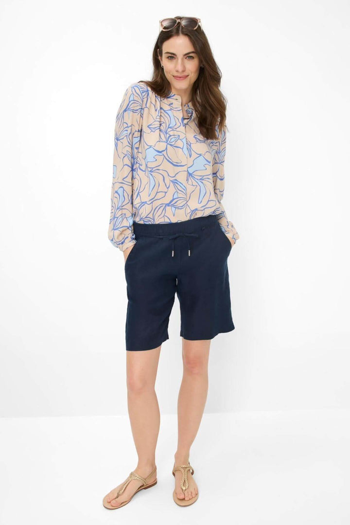 Femme portant un short en lin MEL B avec une blouse à motifs, style décontracté et sophistiqué.