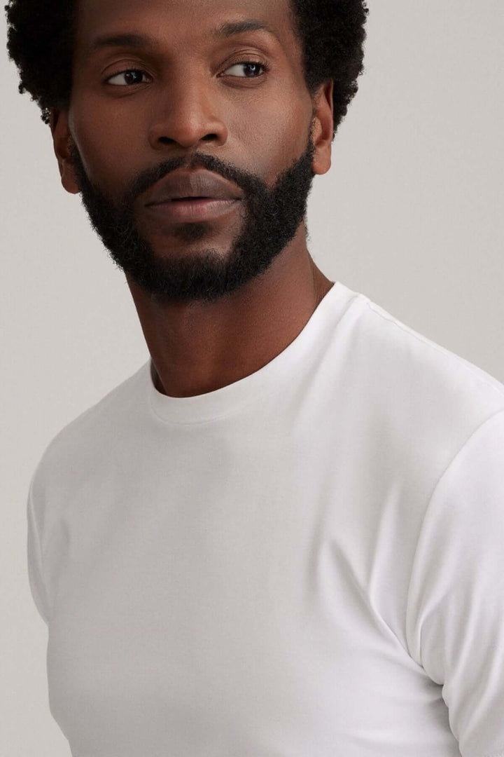 Homme portant un t-shirt blanc moderne avec une coupe épurée et un tissu confortable.