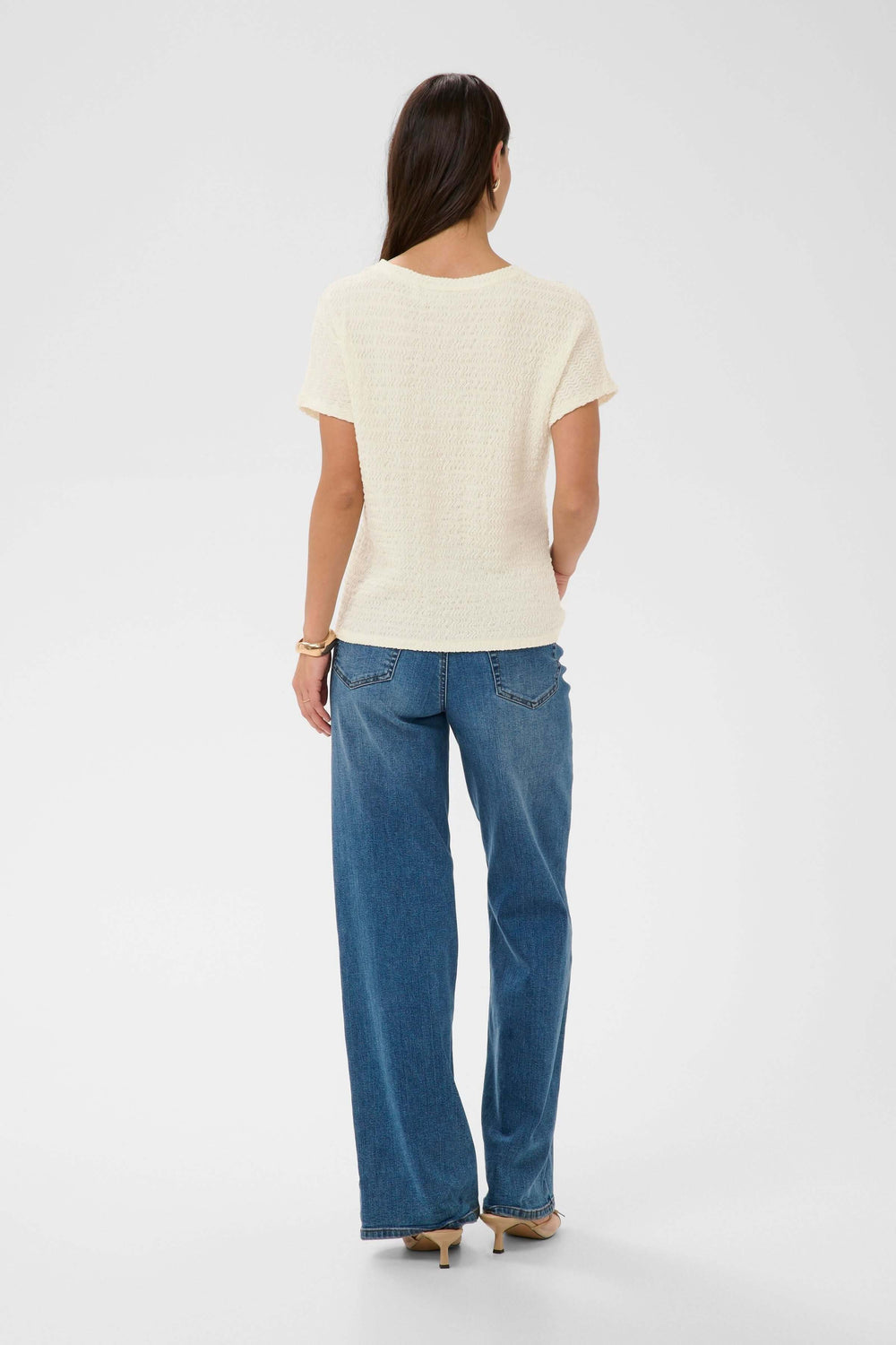 Vue arrière du T-shirt Felecity texturé à manches courtes porté avec un jean, montrant une silhouette simple et élégante.