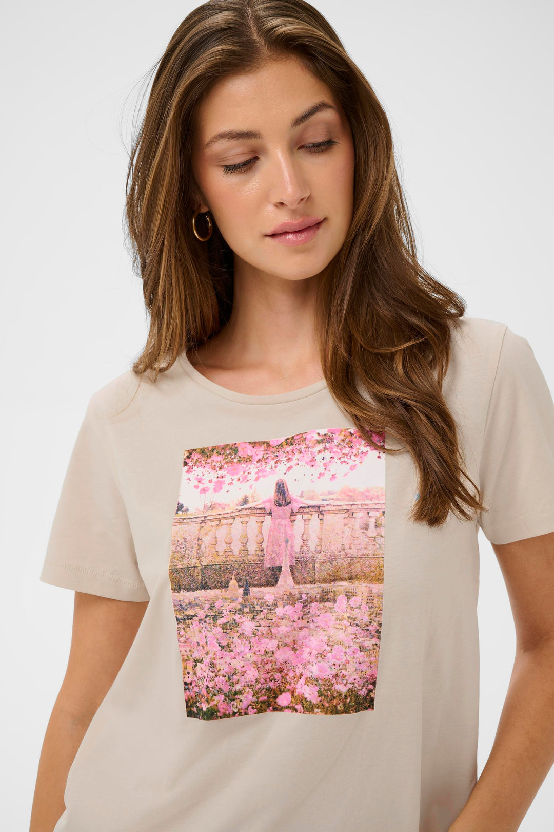 T-shirt Joliy avec imprimé artistique, manches courtes, coupe droite, encolure ronde, porté par une femme, apportant une touche féminine.