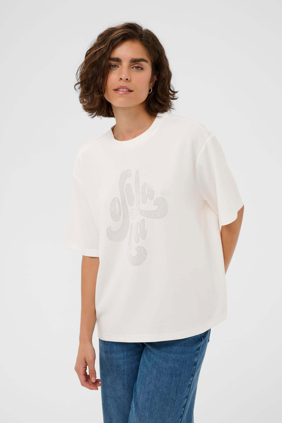 Femme portant un T-shirt Rosie coupe ample avec motif décoratif sur le devant, style moderne et décontracté, encolure ronde, manches courtes.