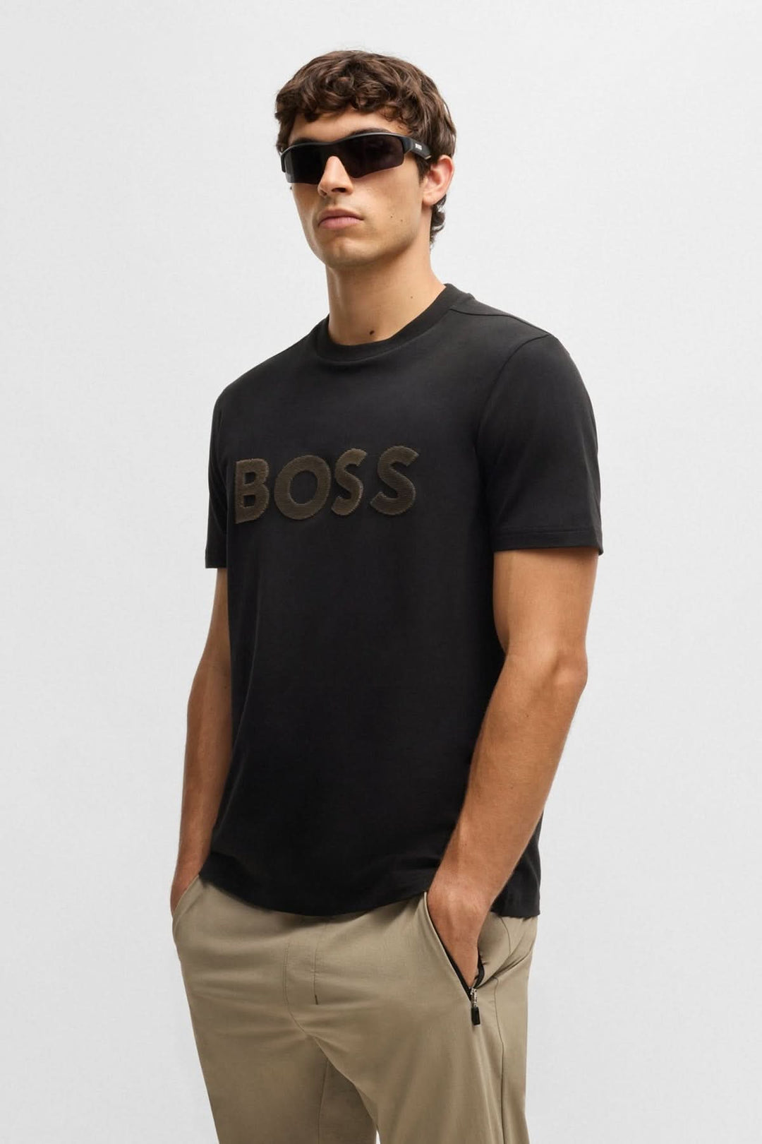 Homme portant un t-shirt noir avec logo BOSS en relief, parfait pour un look casual chic.