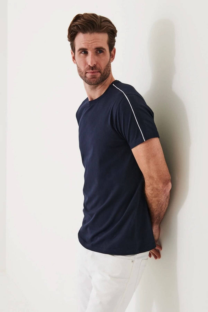 Homme portant un t-shirt navy à col rond avec ligne blanche, en coton pima, coupe régulière.