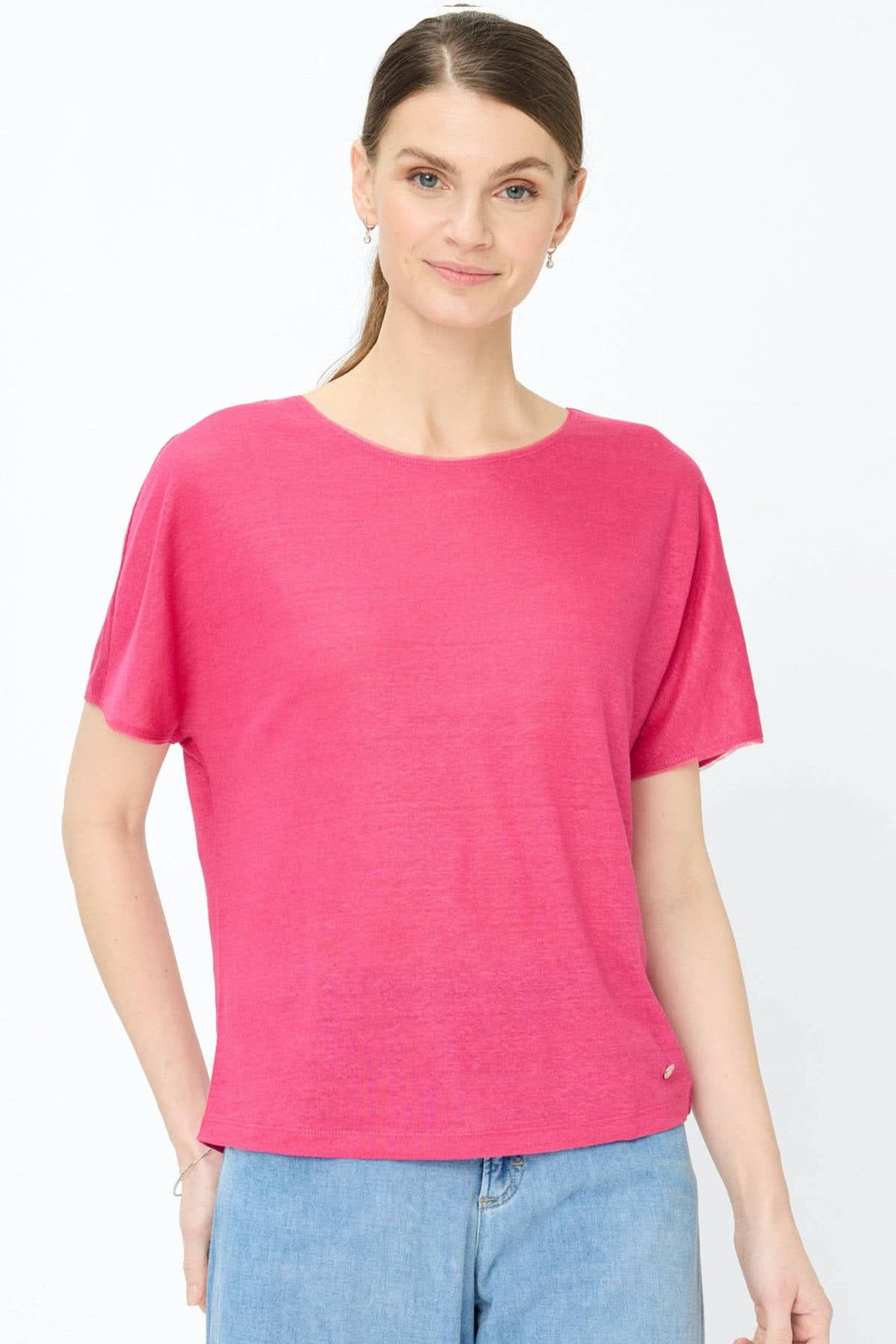 Femme portant un T-shirt col bateau Caelen rose, coupe fluide et manches courtes, associé à un jean, mode confortable et moderne.