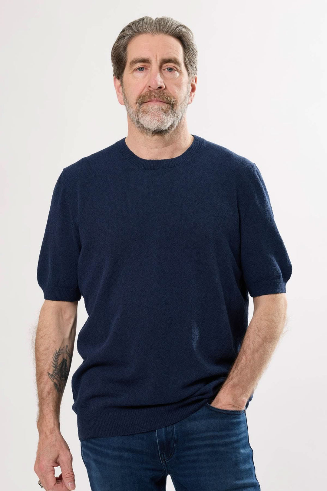 Homme portant un t-shirt élégant bleu marine, alliant confort et simplicité raffinée.