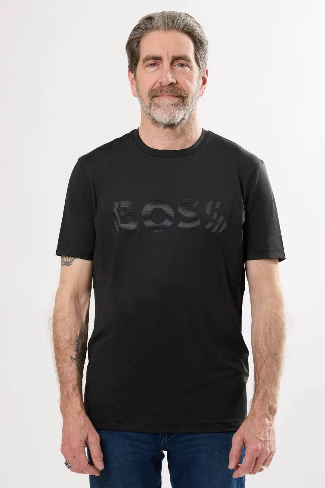 Homme portant un t-shirt noir à logo BOSS, style sportif et confortable, manche courte, encolure ronde.