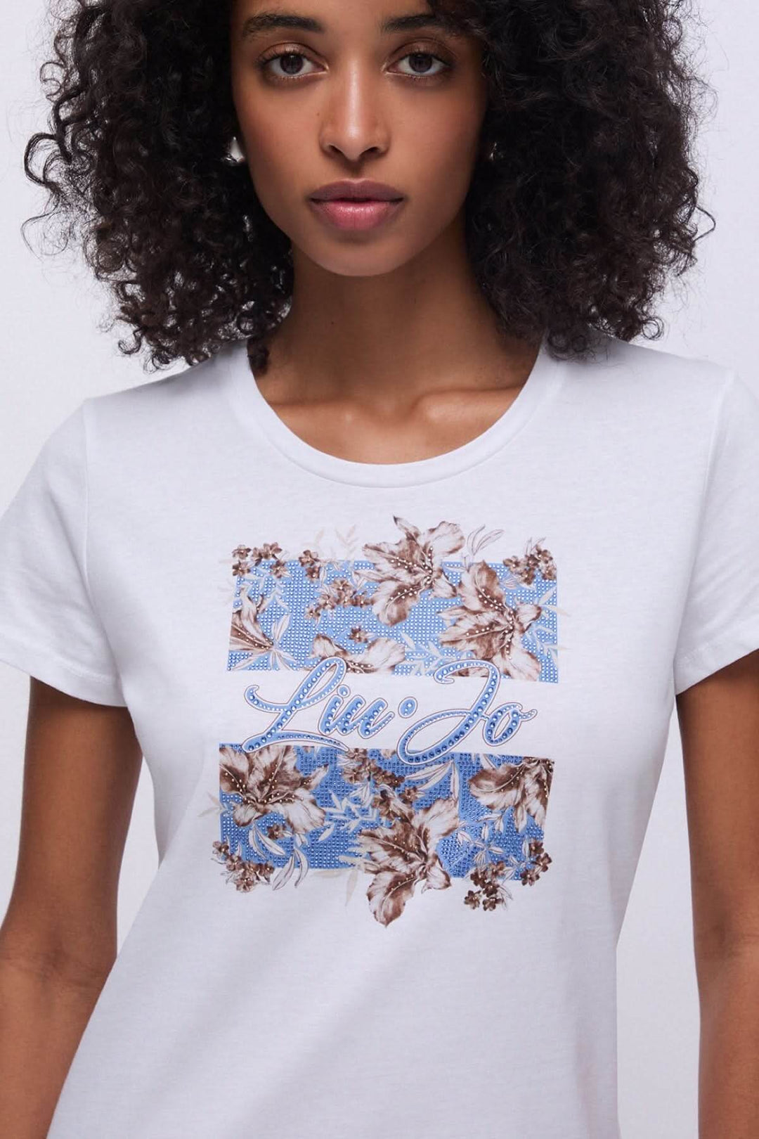 T-shirt à manches courtes avec imprimé graphique sur fond blanc. Design moderne et féminin.