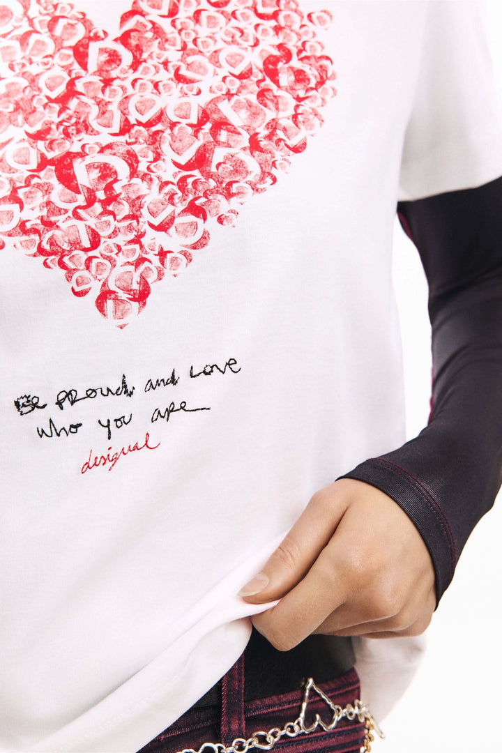 T-shirt à manches courtes coeur avec imprimé graphique de lettres formant un cœur et message inspirant, porté par une personne.