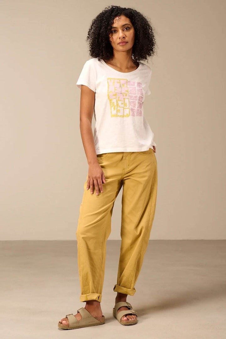 Femme portant un T-shirt à manches courtes coupe décontractée avec pantalon jaune et sandales, montrant un style estival décontracté.