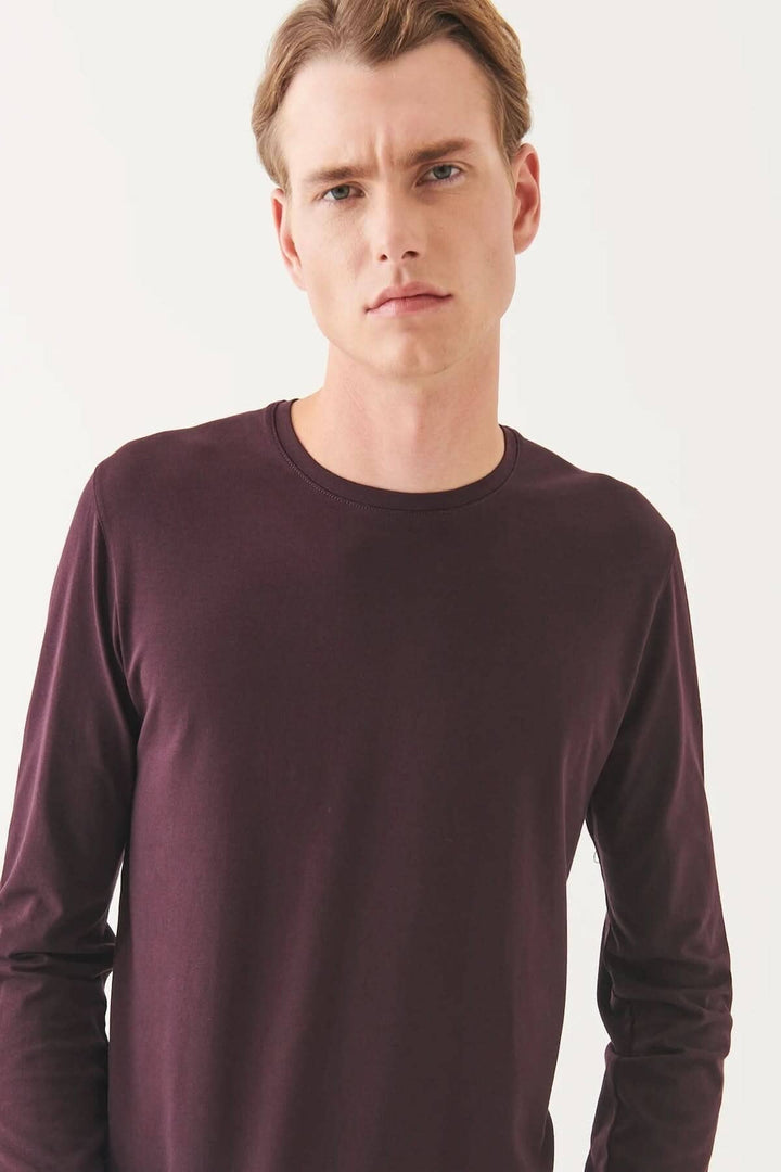 Homme portant un t-shirt manches longues en coton Pima péruvien de couleur prune, col rond et coupe confortable.