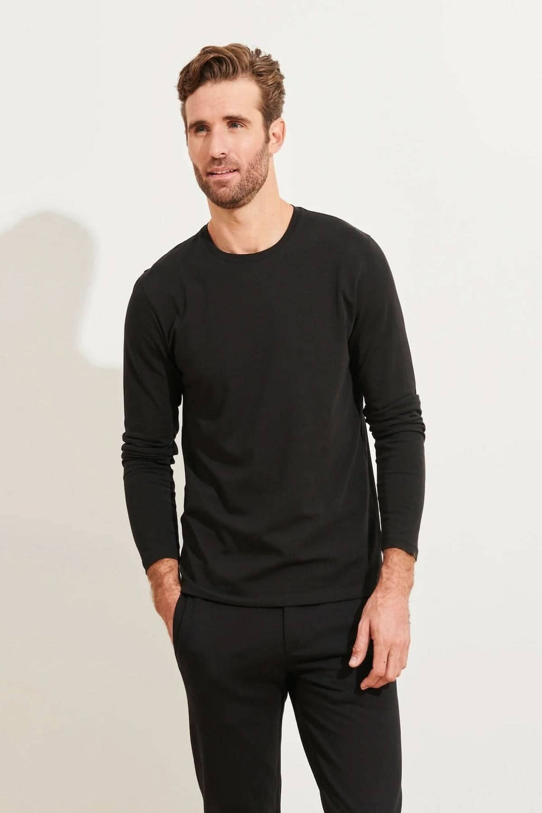 Homme portant un t-shirt noir à manches longues et col rond en coton Pima, idéal pour le confort quotidien.