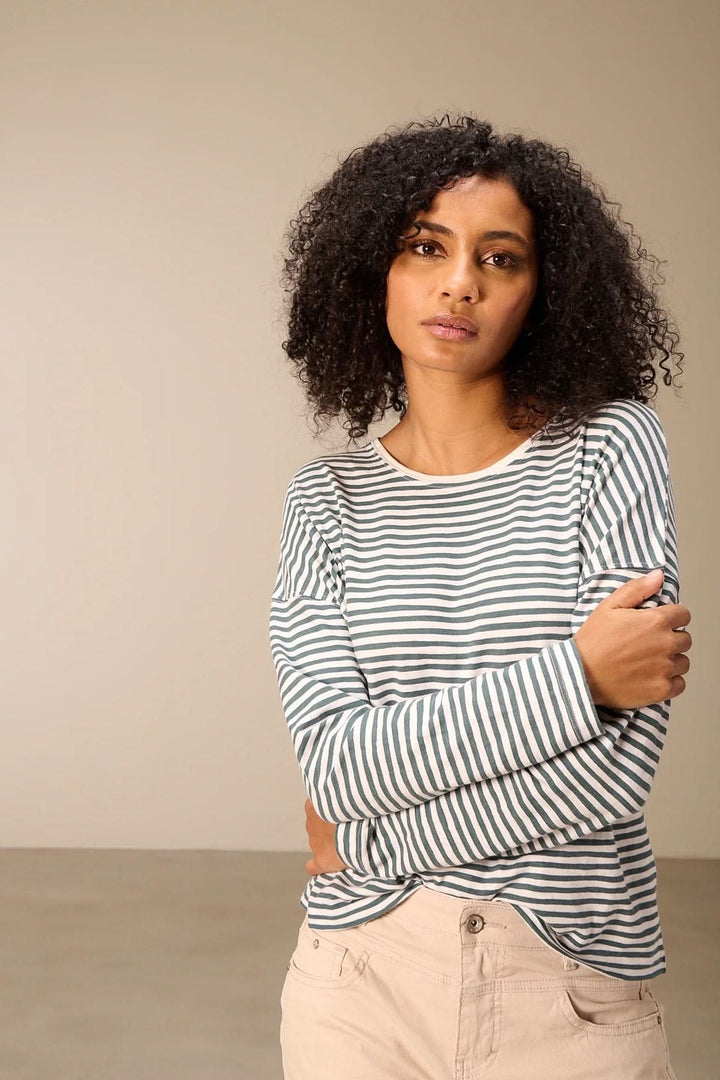 Femme portant un T-shirt à manches longues rayé col rond dans un style décontracté.