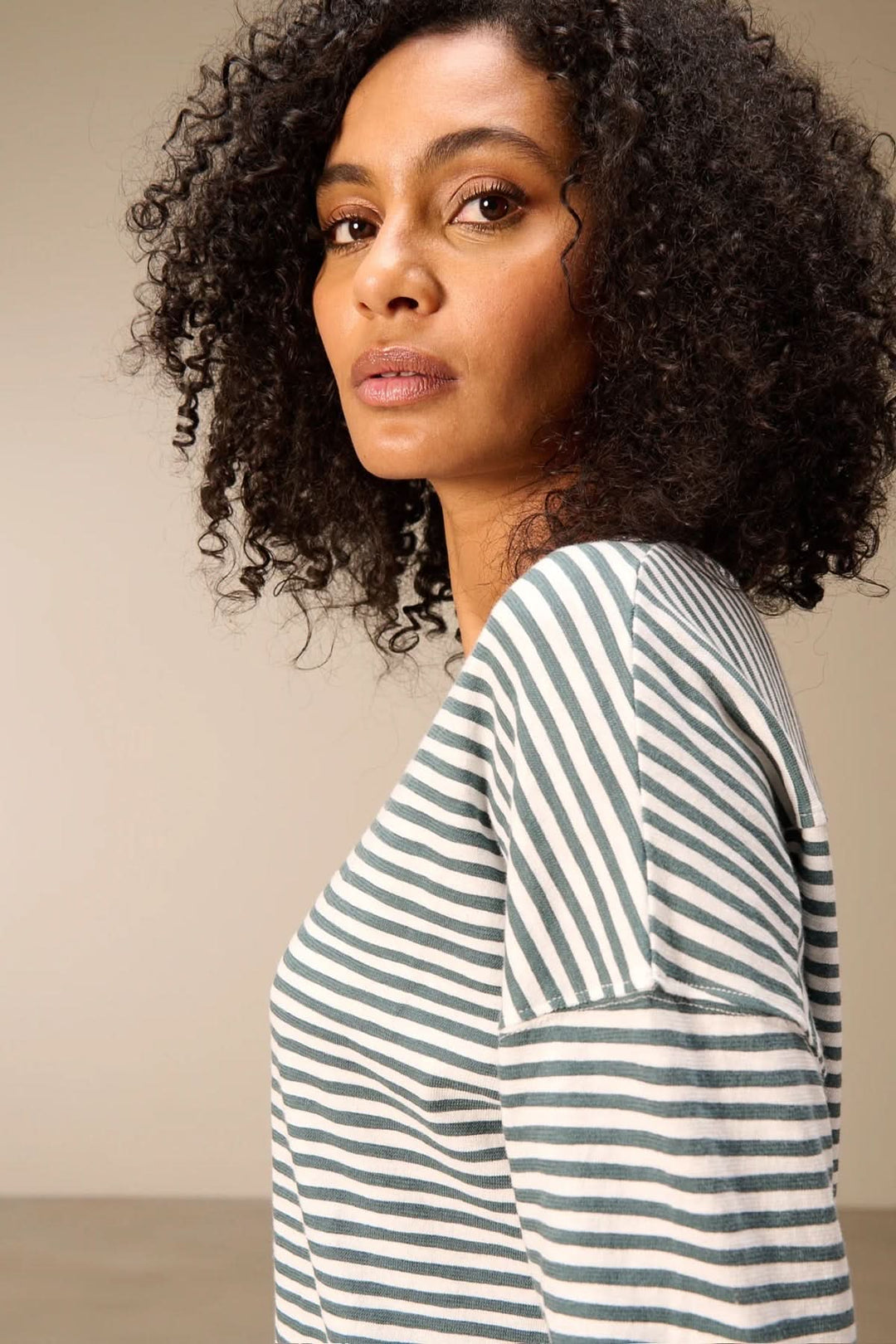 Femme portant un t-shirt à manches longues rayé col rond avec motif à rayures et épaules tombantes.