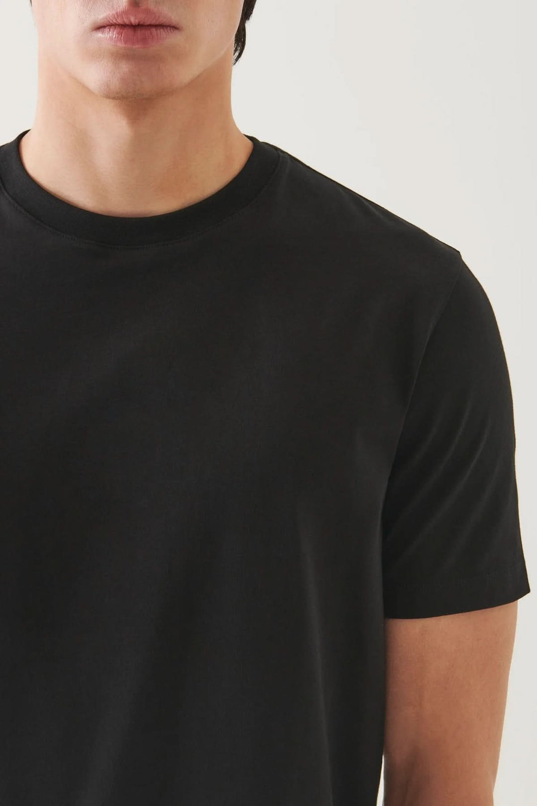 T-shirt minimaliste noir à col rond, coupe droite, manches courtes, style épuré et confortable.