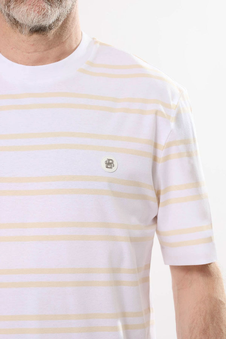 T-shirt rayé blanc et jaune avec écusson brodé, idéal pour un look décontracté et estival.