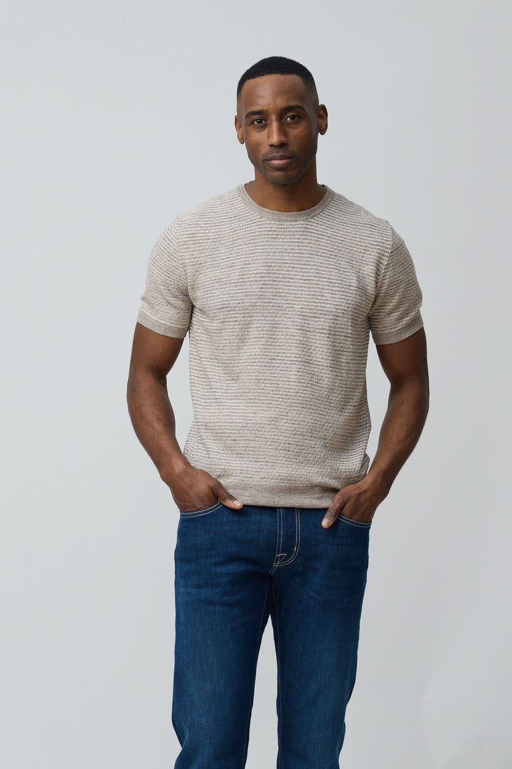 Homme portant un T-shirt texturé en lin et soie, coupe ajustée et manches courtes, style moderne et épuré, tissu léger et respirant.