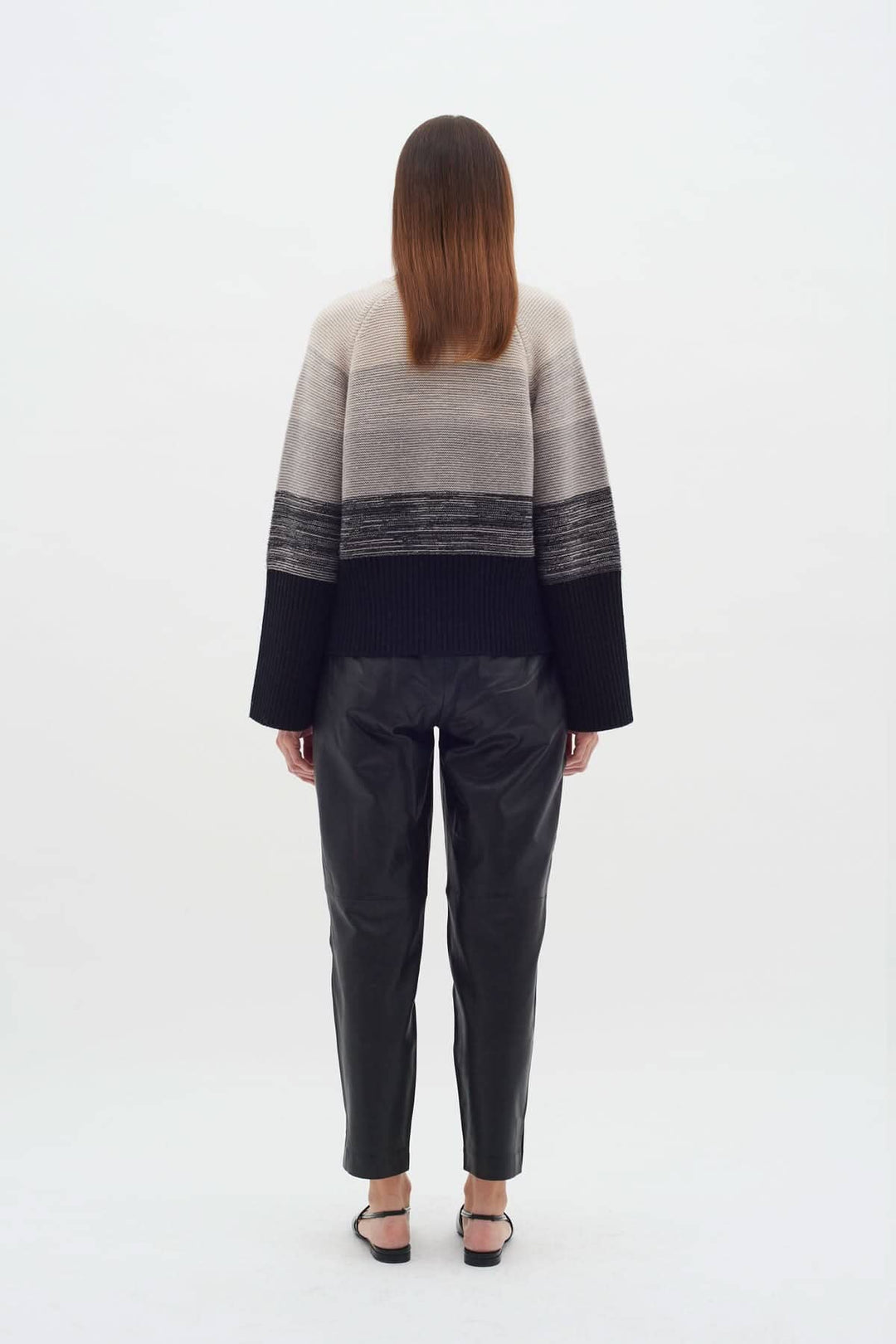 Vue arrière du Tricot Kaxy, pull côtelé extensible à rayures neutres, porté avec un pantalon en cuir.