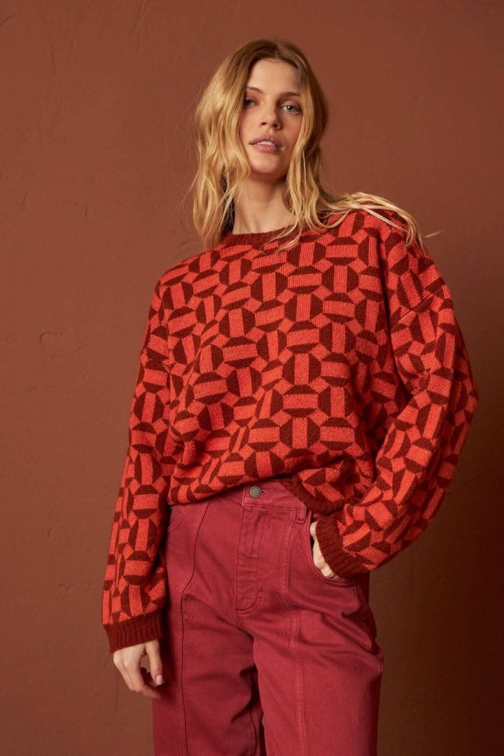 Tricot à manches longues avec motifs géométriques en rouge, coupe ample et tendance.
