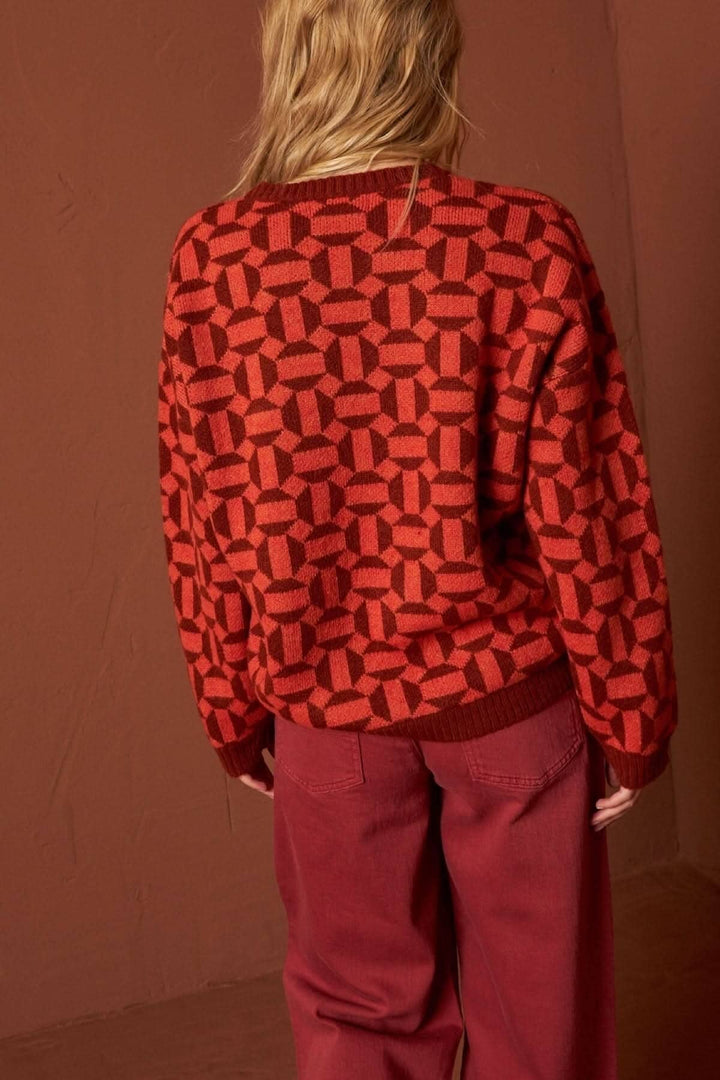 Tricot à manches longues rouge à motifs géométriques, porté avec un pantalon assorti, vue arrière.