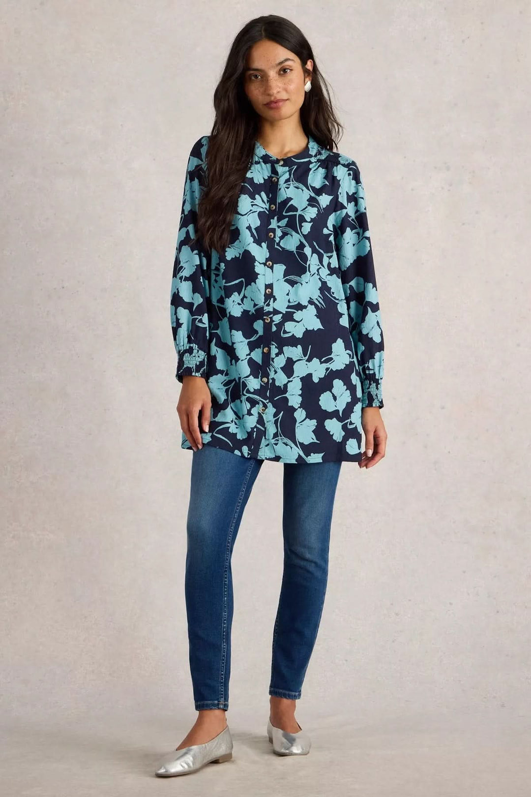 Tunique Amy avec imprimé botanique, manches longues, portée avec un jean et des chaussures argentées.