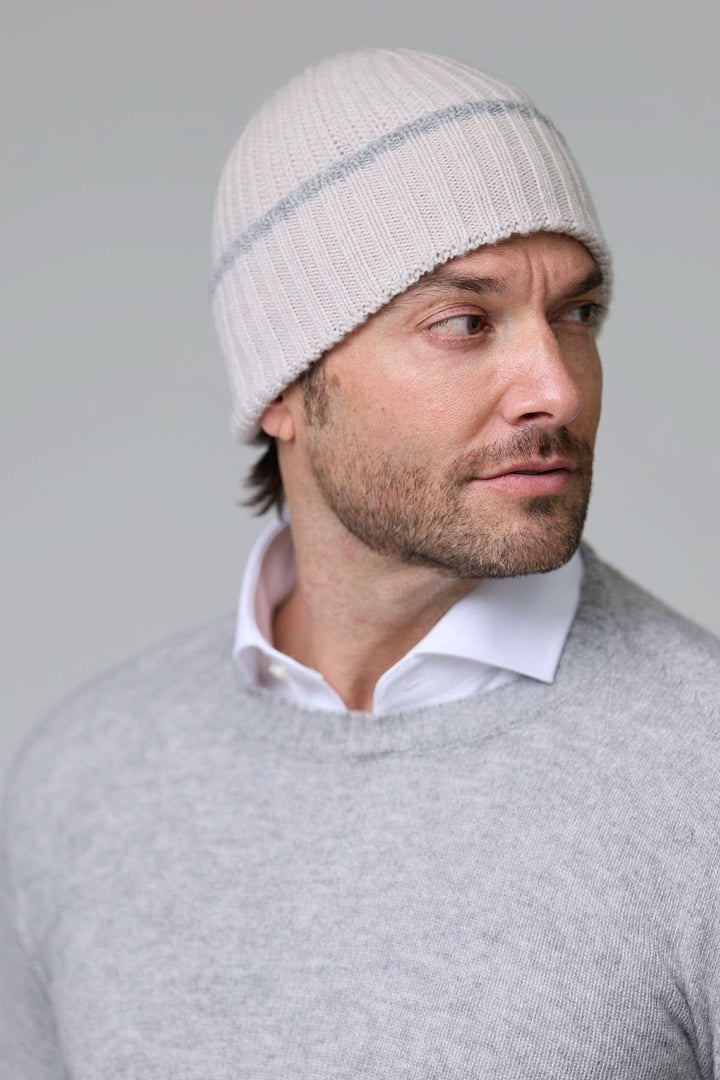 Homme portant une tuque en tricot côtelé blanche, style décontracté et chaud pour l'hiver.
