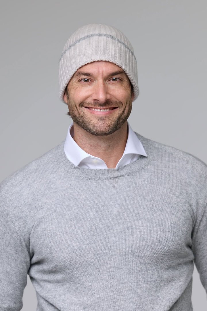 Homme portant une tuque en tricot côtelé grise pour affronter le froid avec style et confort.