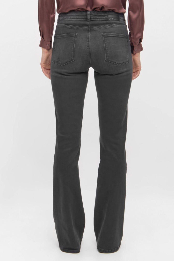 Jean noir à coupe évasée vu de dos, stylisé avec une chemise en satin, offrant un look chic et moderne.