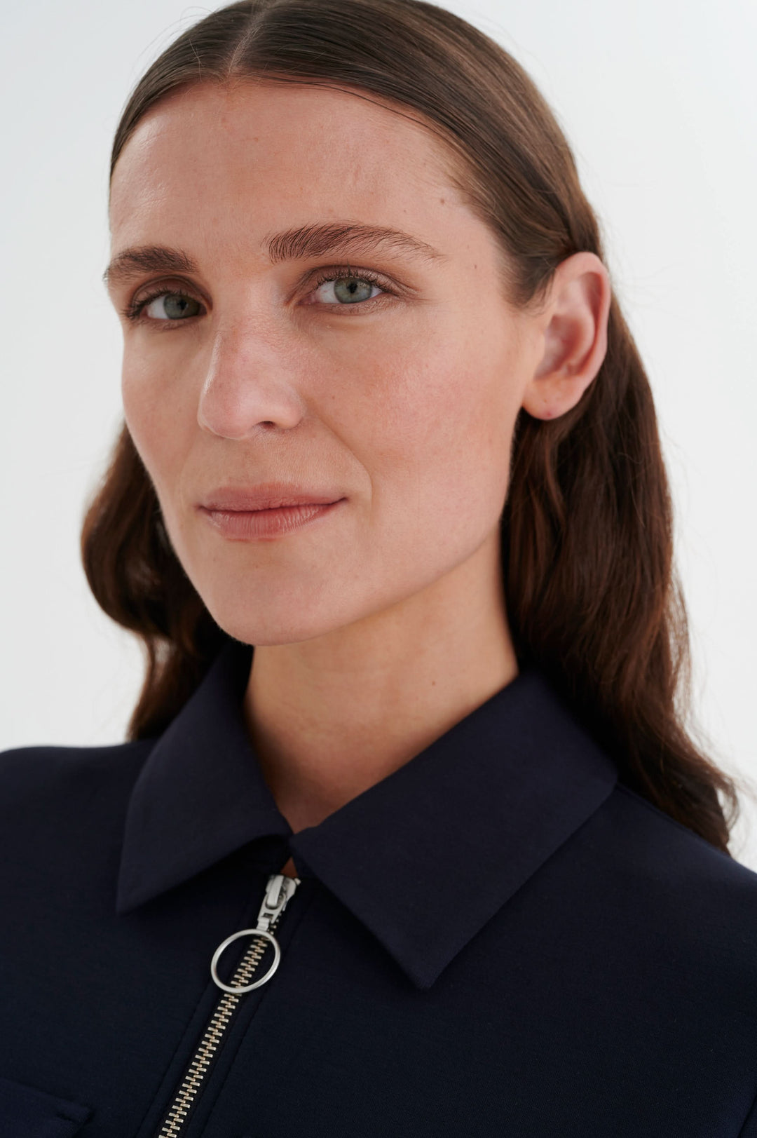 Femme portrait portant une veste à fermeture éclair, avec un col. Style urbain et chic en bleu marine.