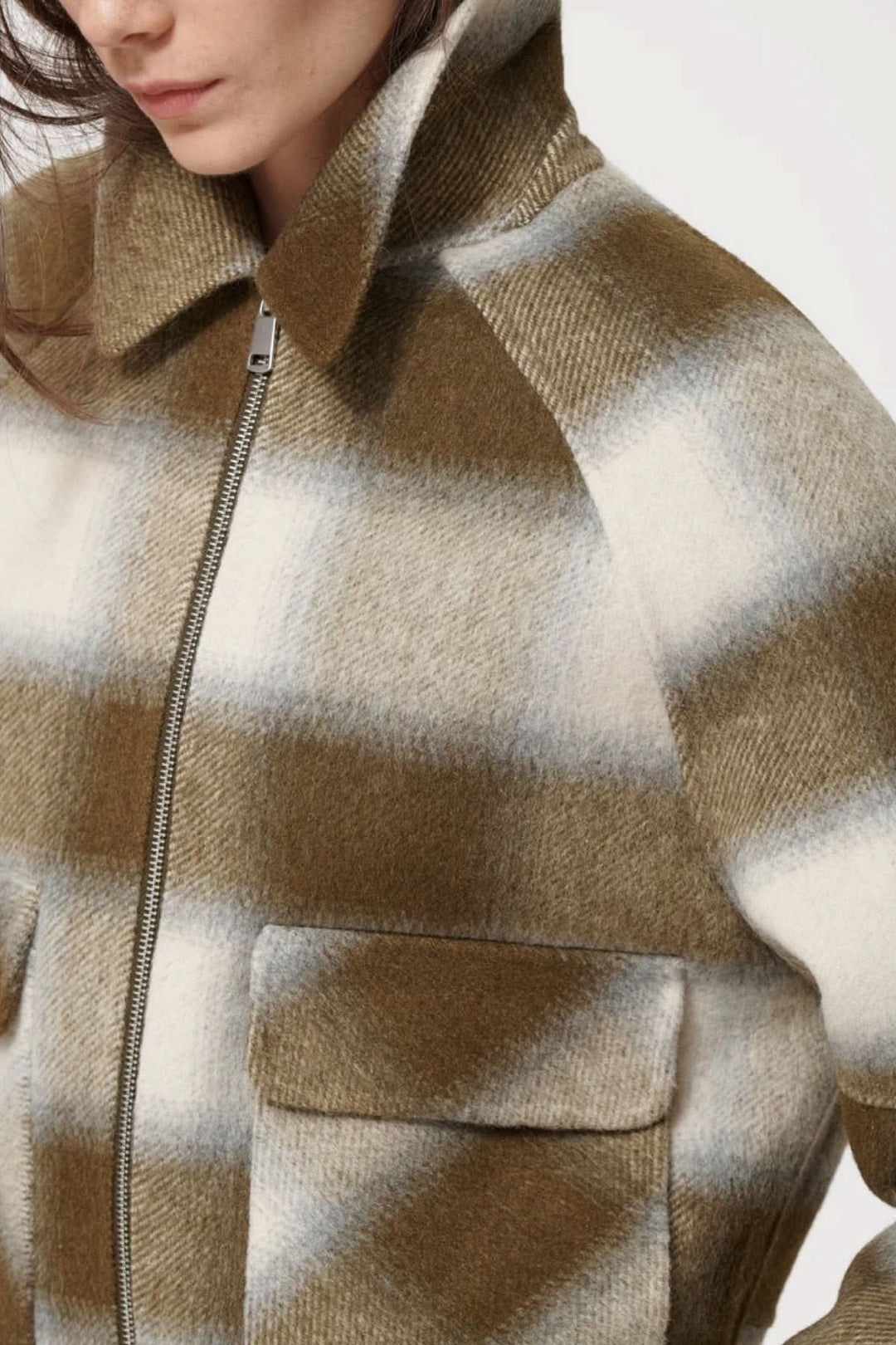 Veste courte à carreaux avec zip frontal, poches à rabat, et col classique, idéale pour superpositions automnales.
