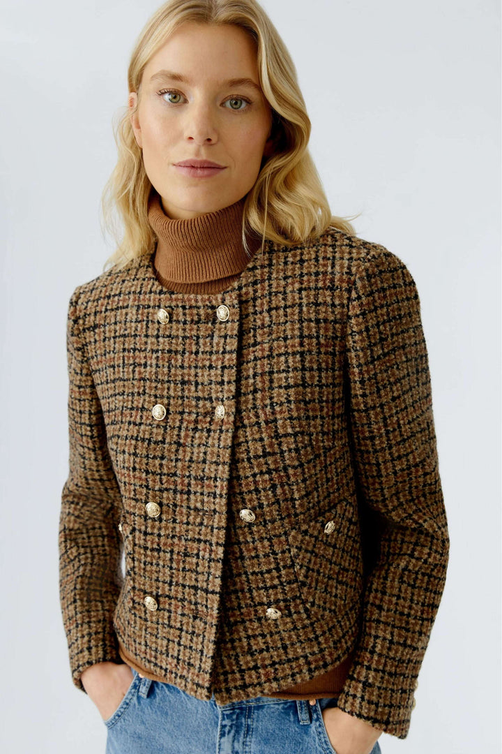 Veste courte à carreaux, boutons dorés en lainage texturé, élégante et intemporelle, portée avec un col roulé et un jean.