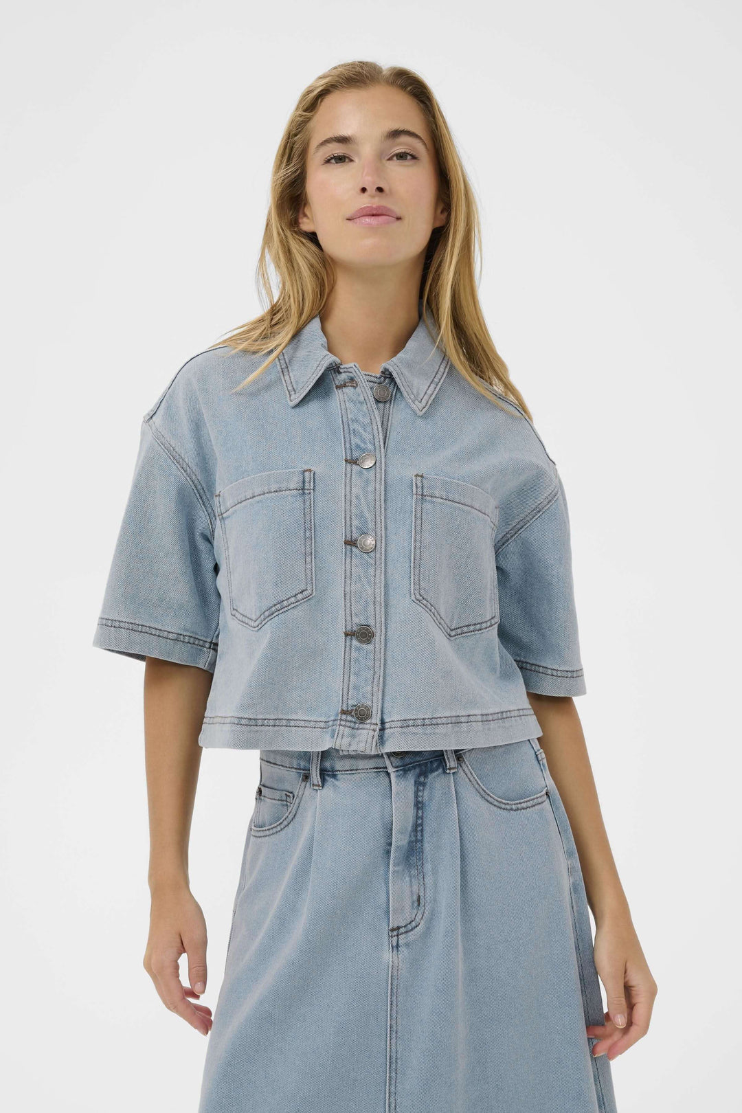 Veste courte en denim à manches courtes avec col classique et poches poitrine plaquées, idéale pour un look décontracté et stylé.