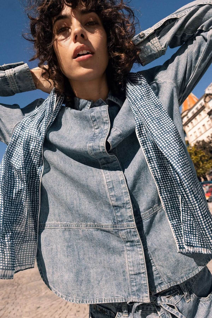 Veste en jean à manches longues en denim souple portée en extérieur pour un style décontracté.