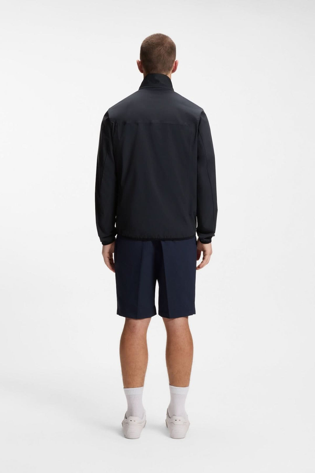 Homme portant une veste légère zippée à col montant, vue de dos, idéale pour un style décontracté ou sportif.
