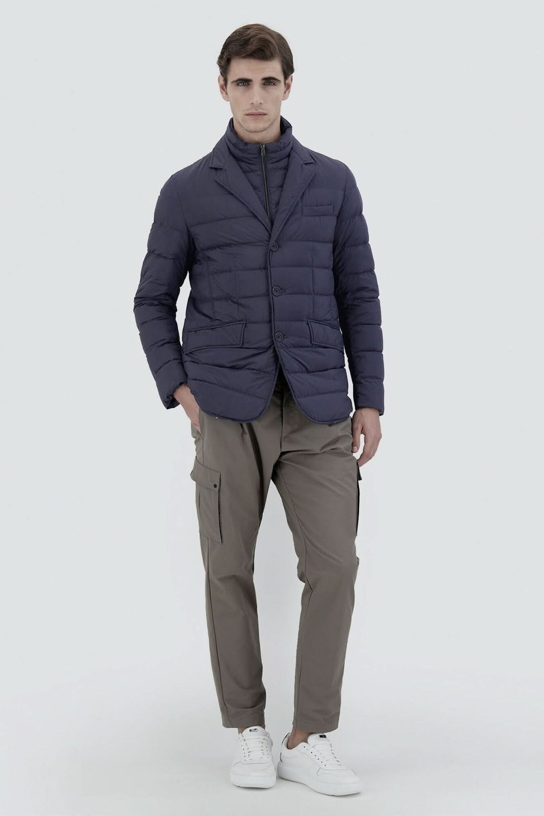 Blazer matelassé moderne en bleu, combiné avec pantalon cargo et chaussures blanches, style élégant.