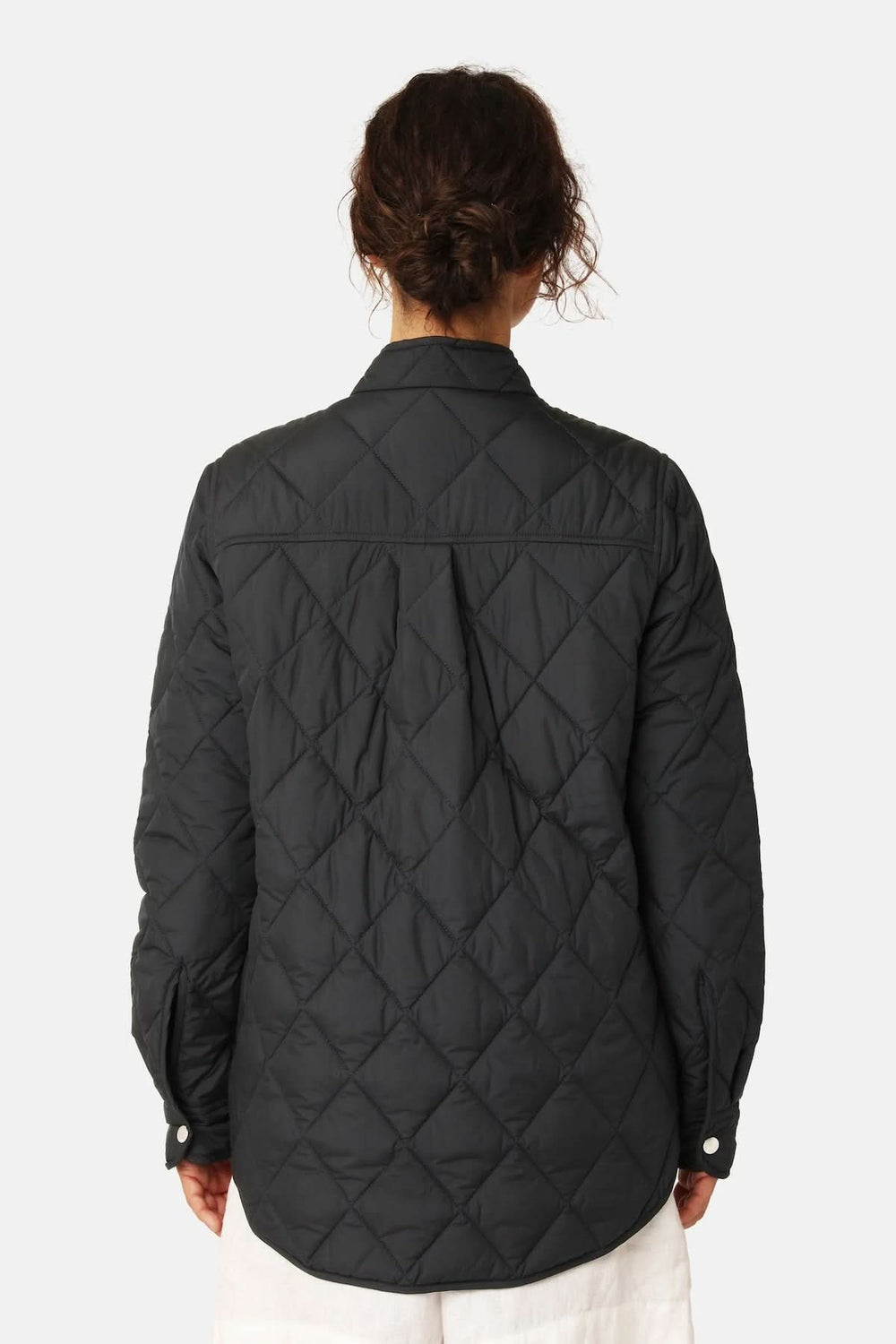 Vue arrière de la veste matelassée légère à col montant en noir avec piquage losange, manches longues et fermeture à boutons-pression.